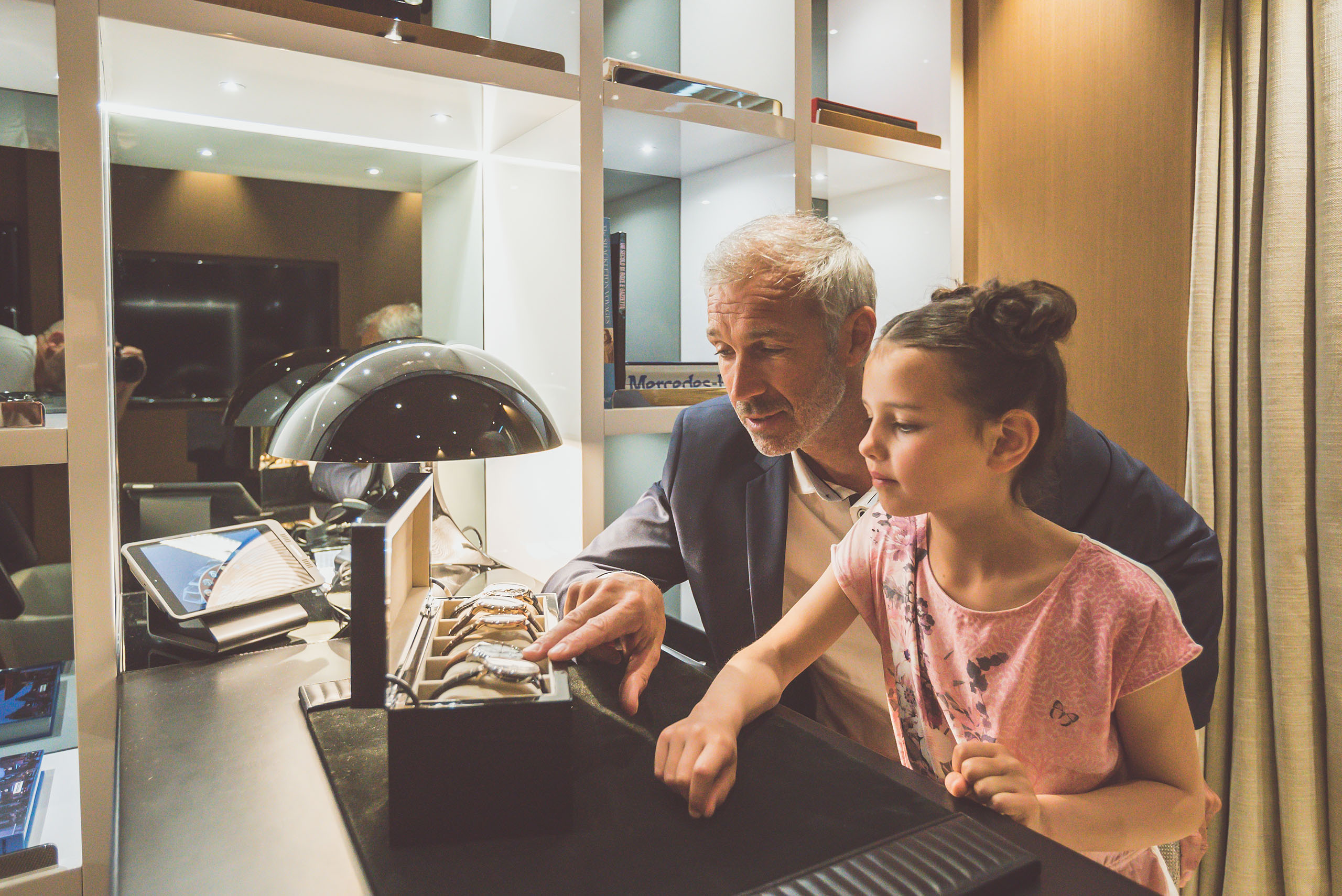 Yacht owner showing his watch collection to young daughter